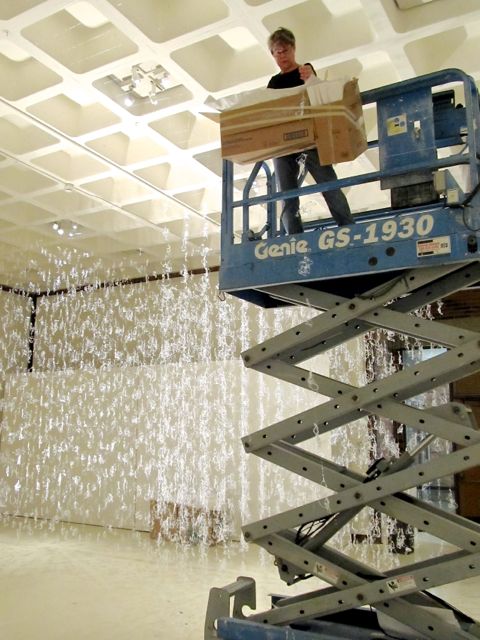 artist Gerri Sayler working on hot glue installation titled Numinous for Spurgeon Art Gallery